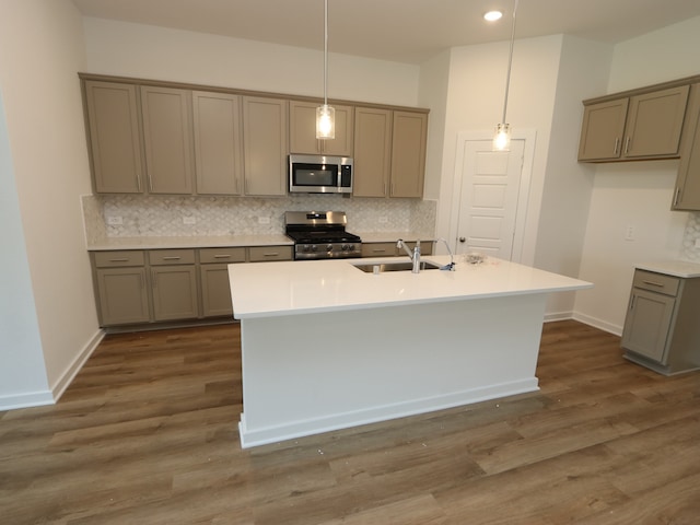22450 Birchfield Grove Ln, New Caney, TX 77357 - kitchen with stainless steel appliances, gray cabinetry, backsplash, a sink, and pendant lighting