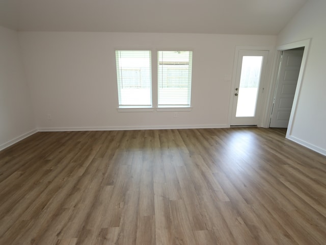 22450 Birchfield Grove Ln, New Caney, TX 77357 - unfurnished living room with wood finished floors, vaulted ceiling, and baseboards