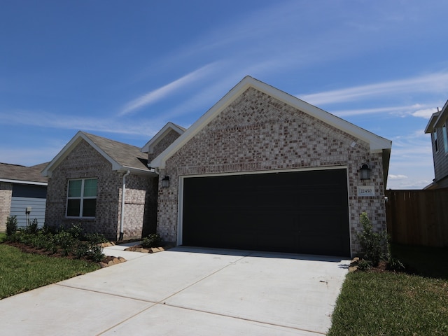 22450 Birchfield Grove Ln, New Caney, TX 77357 - ranch-style house featuring an attached garage, driveway, and brick siding