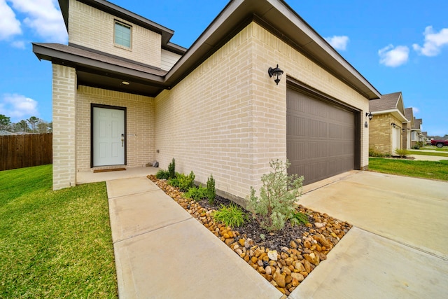 exterior space with a garage, brick siding, fence, driveway, and a lawn