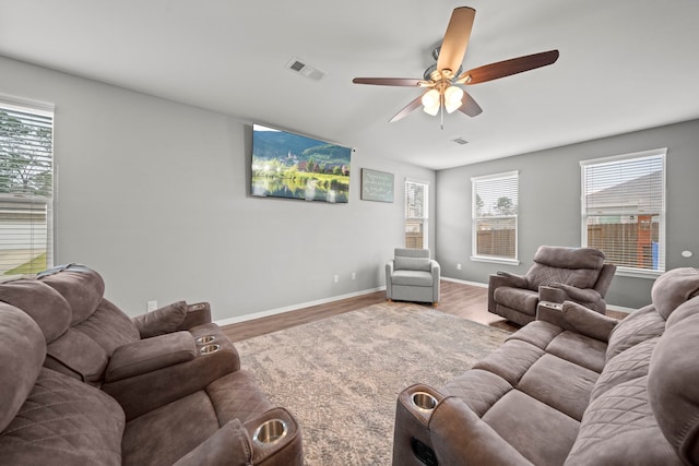 living room featuring a wealth of natural light, wood finished floors, and visible vents