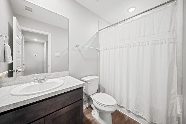 full bathroom featuring visible vents, a shower with shower curtain, toilet, wood finished floors, and vanity