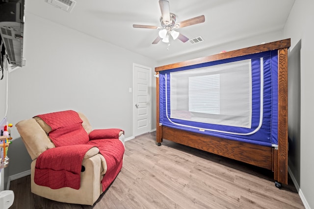 living area featuring visible vents, baseboards, and wood finished floors