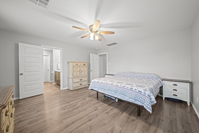 bedroom featuring baseboards, visible vents, and wood finished floors
