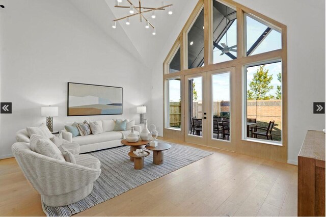 446 Silver Moon Way, Katy, TX 77493 - living room featuring wood finished floors, french doors, high vaulted ceiling, a chandelier, and baseboards