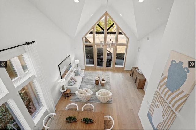 dining room featuring light wood finished floors, recessed lighting, high vaulted ceiling, and french doors