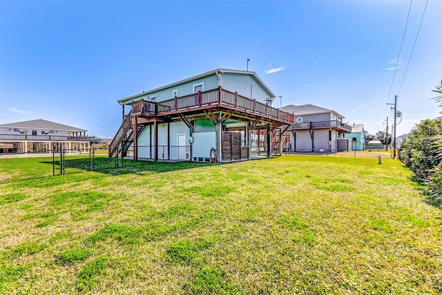 rear view of house featuring a deck, a yard, stairway, and fence