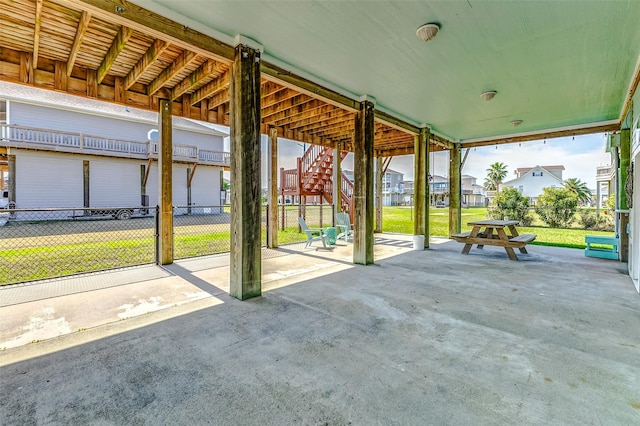 view of patio featuring fence, stairway, and a residential view