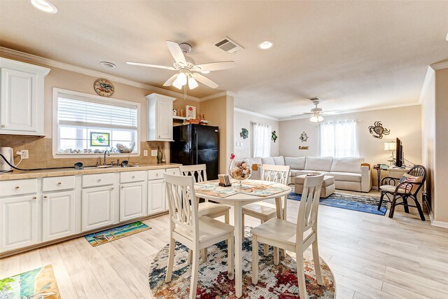 dining space featuring a healthy amount of sunlight, light wood finished floors, and visible vents