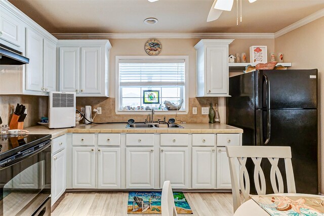 kitchen featuring black appliances, a sink, light countertops, and white cabinets