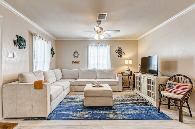 living room featuring a ceiling fan, visible vents, crown molding, and wood finished floors