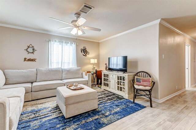 living room with visible vents, baseboards, ceiling fan, ornamental molding, and light wood-style floors