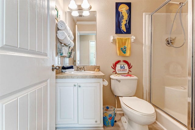 full bathroom featuring a stall shower, crown molding, vanity, and toilet