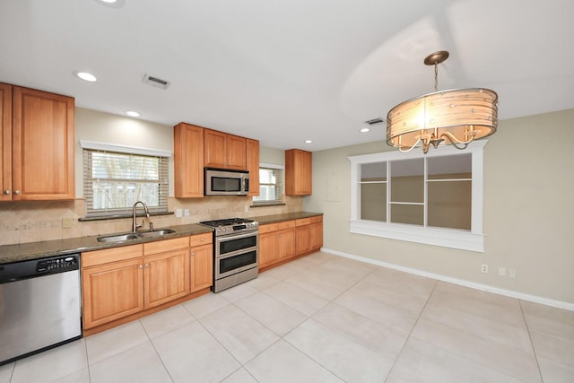 kitchen with stainless steel appliances, tasteful backsplash, visible vents, a sink, and baseboards