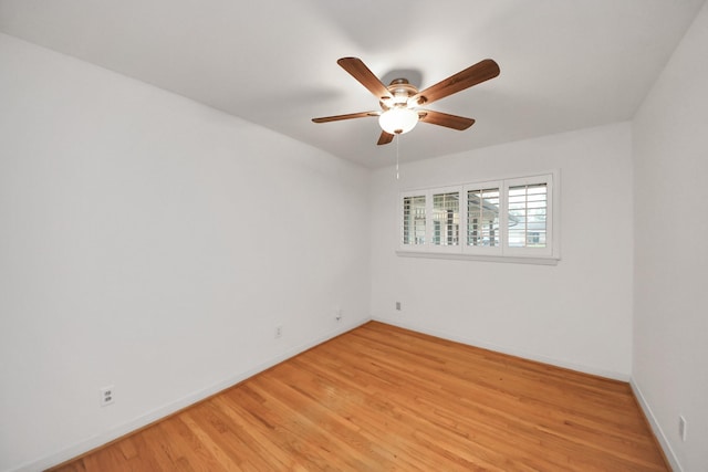 unfurnished room featuring ceiling fan, light wood-type flooring, and baseboards