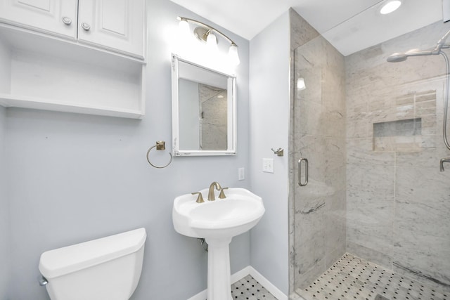 bathroom featuring a stall shower, baseboards, and toilet