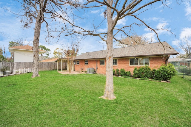 rear view of property with a patio area, a fenced backyard, a lawn, and brick siding