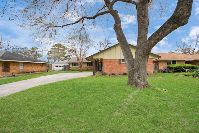 view of front facade with driveway, a front lawn, board and batten siding, and brick siding