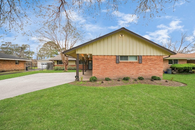 view of front facade with concrete driveway, brick siding, and a front lawn