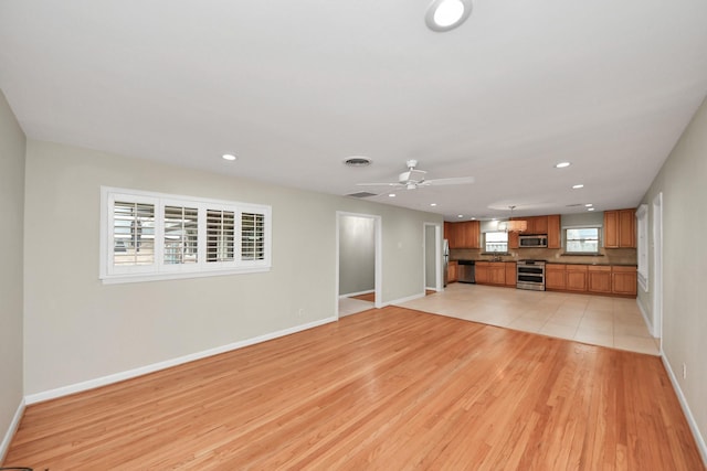 unfurnished living room with baseboards, ceiling fan, light wood-type flooring, and recessed lighting