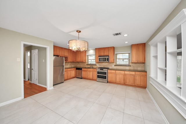 kitchen with appliances with stainless steel finishes, visible vents, baseboards, and light tile patterned floors