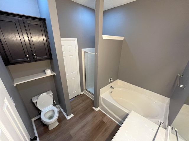 full bath with a garden tub, toilet, a stall shower, wood finished floors, and baseboards