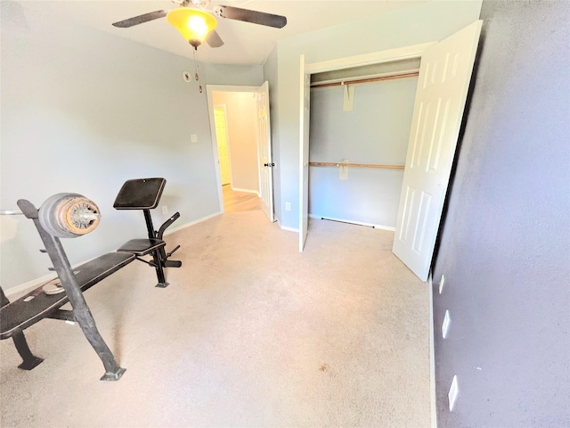 exercise room featuring light colored carpet, ceiling fan, and baseboards