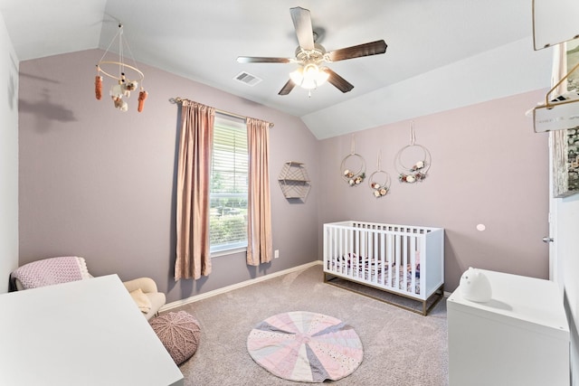 bedroom featuring carpet, visible vents, vaulted ceiling, a crib, and baseboards