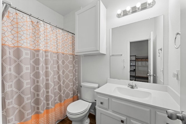 bathroom with toilet, vanity, and a shower with curtain