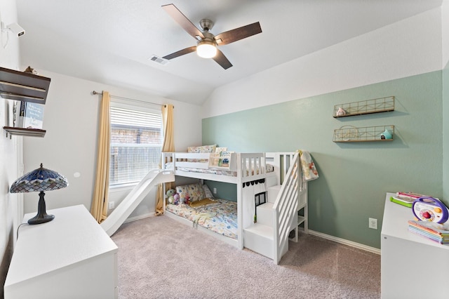 carpeted bedroom with lofted ceiling, baseboards, visible vents, and a ceiling fan