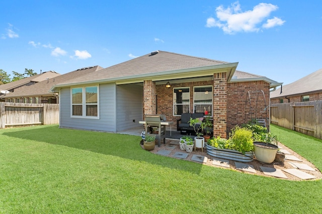 rear view of property featuring a patio area, brick siding, a lawn, and a fenced backyard