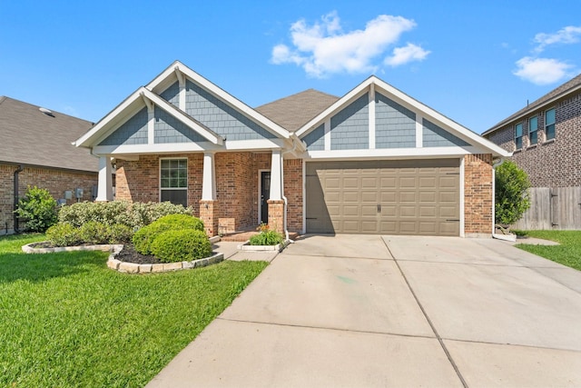 craftsman-style home featuring driveway, an attached garage, fence, a front lawn, and brick siding