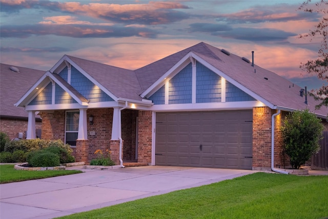 craftsman-style house with a garage, driveway, brick siding, and a front yard