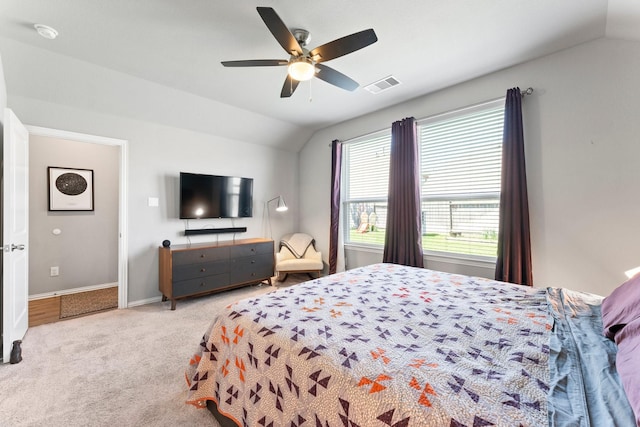 carpeted bedroom featuring lofted ceiling, baseboards, visible vents, and ceiling fan