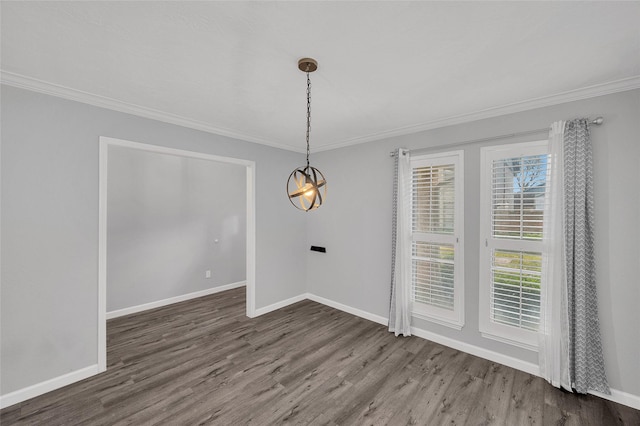 unfurnished dining area featuring crown molding, baseboards, and wood finished floors