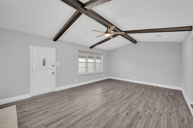 unfurnished living room featuring vaulted ceiling with beams, ceiling fan, wood finished floors, visible vents, and baseboards