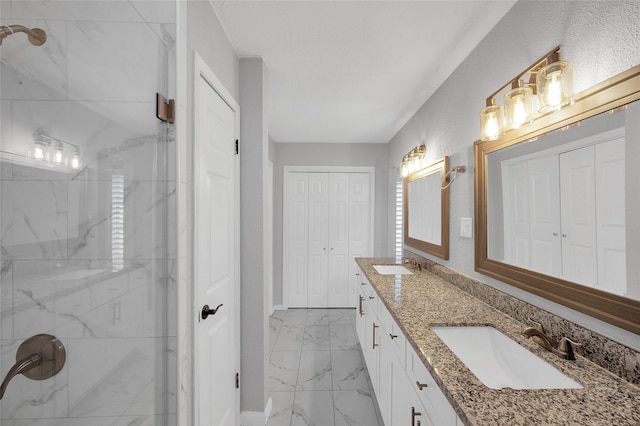 bathroom featuring a closet, marble finish floor, a sink, and a marble finish shower