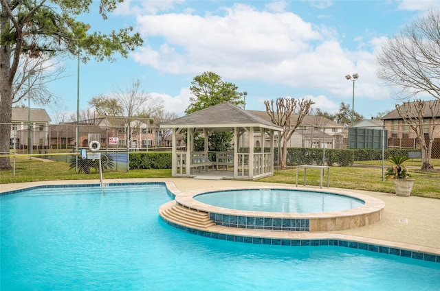 pool with a hot tub, a lawn, a residential view, fence, and a gazebo