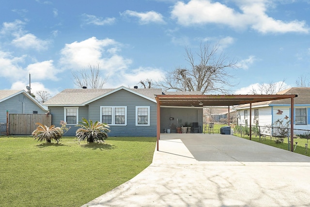 view of front facade with a carport, fence, concrete driveway, and a front yard