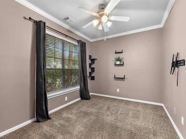 carpeted spare room with baseboards, visible vents, and crown molding