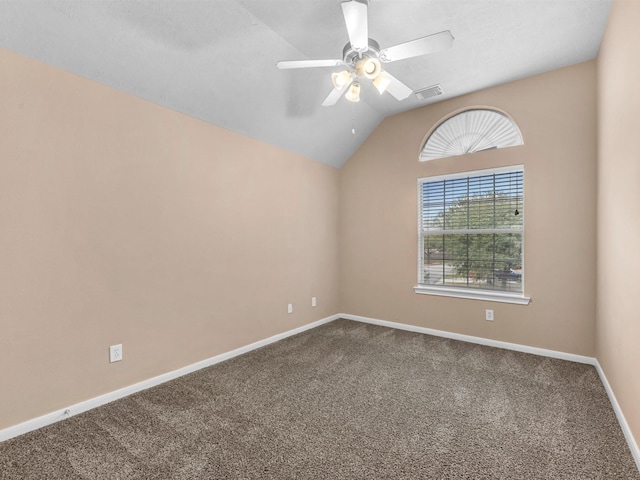 carpeted empty room with baseboards, visible vents, vaulted ceiling, and a ceiling fan