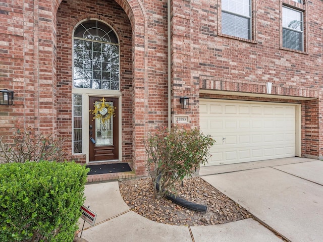 property entrance featuring driveway and brick siding