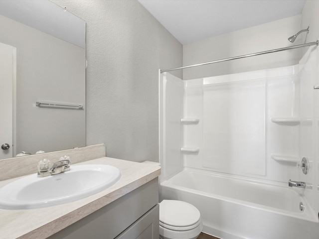 full bathroom with shower / washtub combination, a textured wall, vanity, and toilet