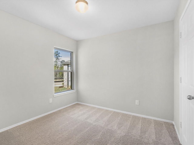 unfurnished room with carpet flooring and baseboards