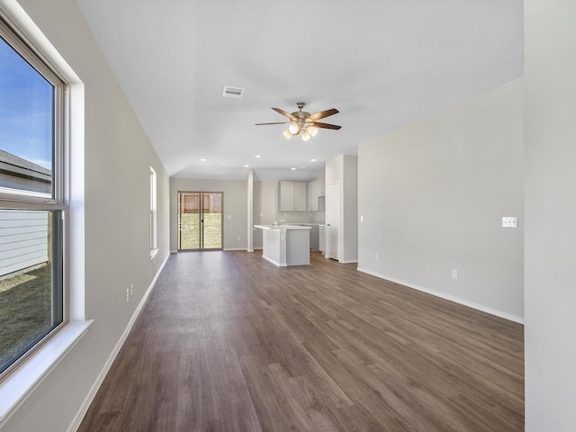 unfurnished living room with dark wood-style flooring, recessed lighting, visible vents, a ceiling fan, and baseboards