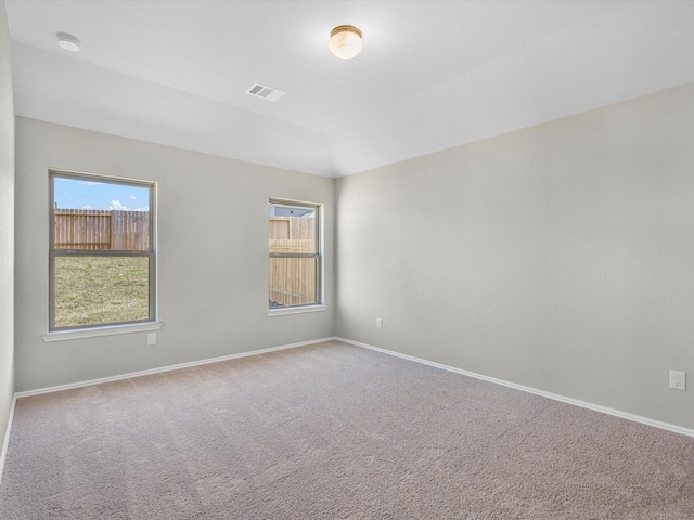 carpeted spare room featuring visible vents and baseboards