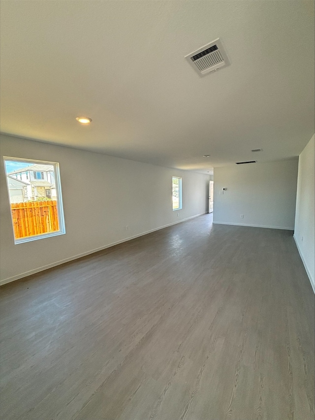 unfurnished room with visible vents, baseboards, and wood finished floors