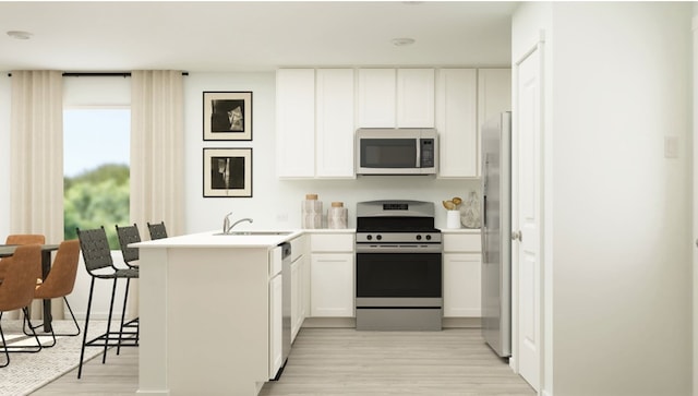 kitchen featuring a peninsula, a sink, white cabinets, appliances with stainless steel finishes, and light wood finished floors