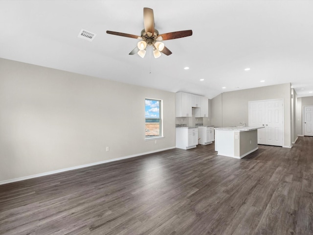 unfurnished living room with dark wood-style floors, recessed lighting, visible vents, ceiling fan, and baseboards