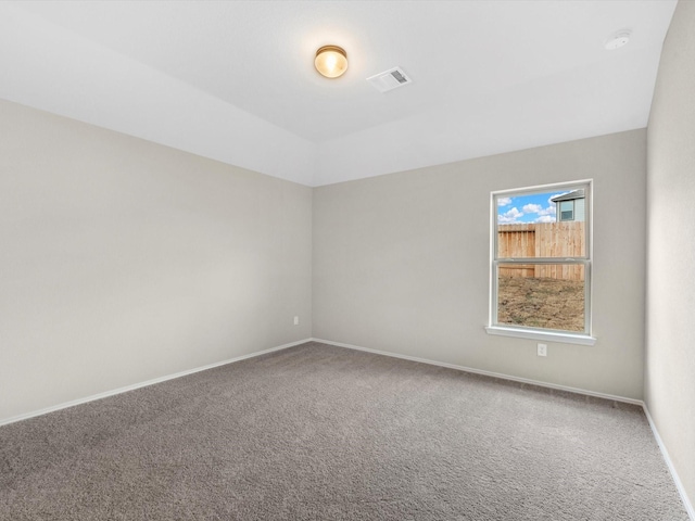 empty room featuring carpet flooring, visible vents, and baseboards